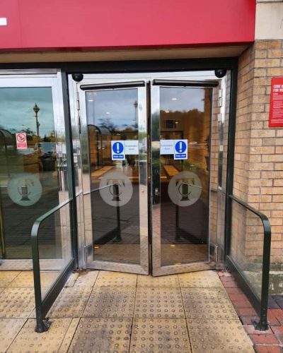 Electric automatic swing doors UK with motorised arms fitted to glass entrance