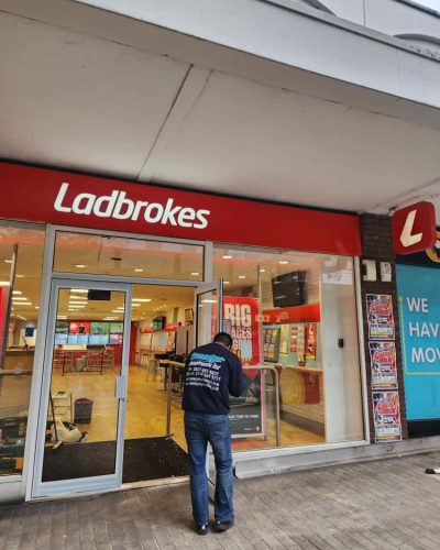 Technician repairing automatic door shopfronts UK in commercial building